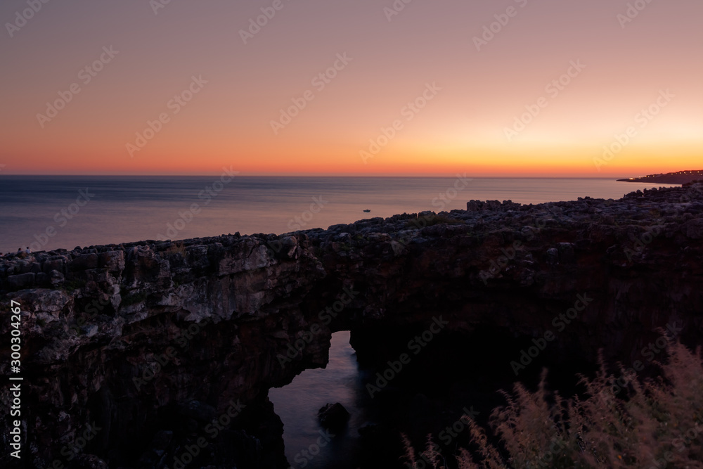 Landscape of chasm Hell's Mouth near Portuguese city of Cascais. A sea cave near Lisbon with natural rock formation, called Boca do Inferno. Sunset view on ocean