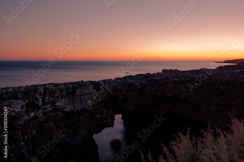 Landscape of chasm Hell's Mouth near Portuguese city of Cascais. A sea cave near Lisbon with natural rock formation, called Boca do Inferno. Sunset view on ocean