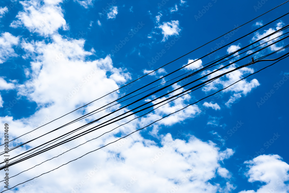 Fototapeta premium The background of electrical wire cable with blue sky for energy power consumption concept and idea