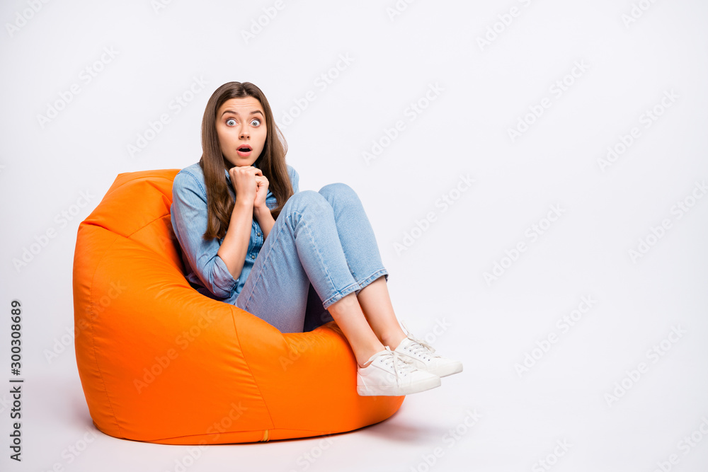 Full size photo of scared girl sit big lounge chair watch horror series feel nervous have shock stay speechless voiceless wear denim jeans outfit sneakers isolated white color background Full size photo of scared girl sit big lounge chair watch horror series feel nervous have shock stay speechless voiceless wear denim jeans outfit sneakers isolated white color background