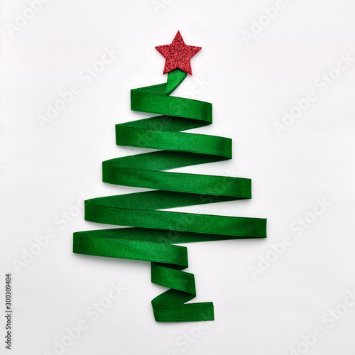 Stylized Christmas tree made from green ribbon with red shiny star on white background