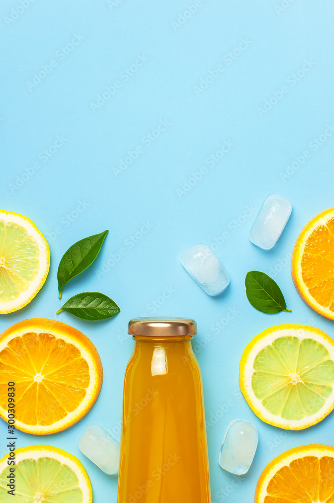 Flat lay composition with glass bottles of juice or fresh, slices of fresh lemon and orange, green leaves, ice cubes on blue background top view copy space. Citrus Juice Concept, Vitamin C, Fruits Flat lay composition with glass bottles of juice or fresh, slices of fresh lemon and orange, green leaves, ice cubes on blue background top view copy space. Citrus Juice Concept, Vitamin C, Fruits