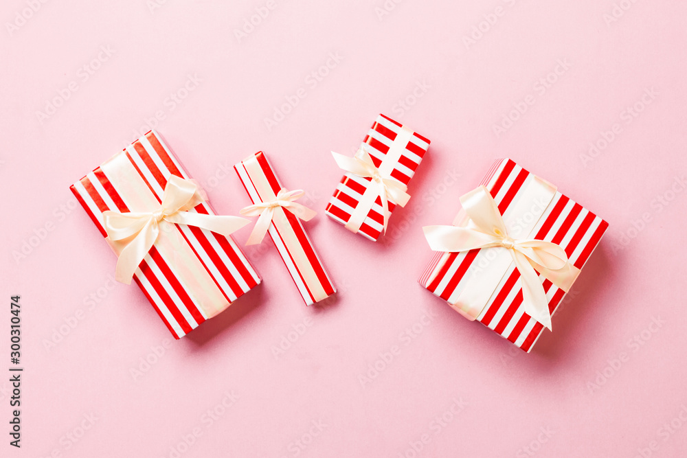 Fototapeta premium Top view Christmas present box with yellow bow on pink background