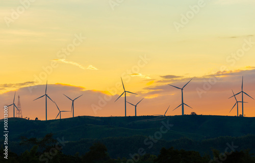 Silhouette of wind turbines at sunset in evening time, alternative energy concept.