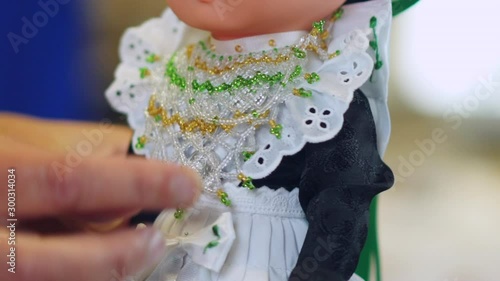 Person touching a doll wearing Sorbiancloth and embroidery. Sorbian traditional costume and dress on a doll for show. photo