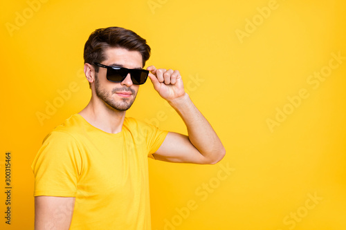 Close-up portrait of his he nice attractive virile masculine brutal serious guy touching specs isolated over bright vivid shine vibrant yellow color background © deagreez