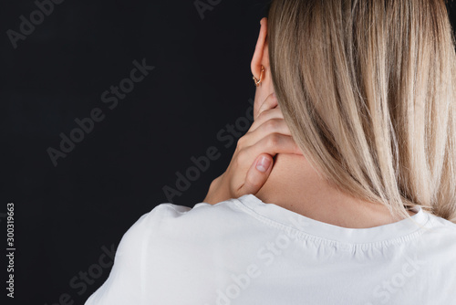 Tableau sur toile Portrait of a girl who holds on to the neck with hands experiencing pain