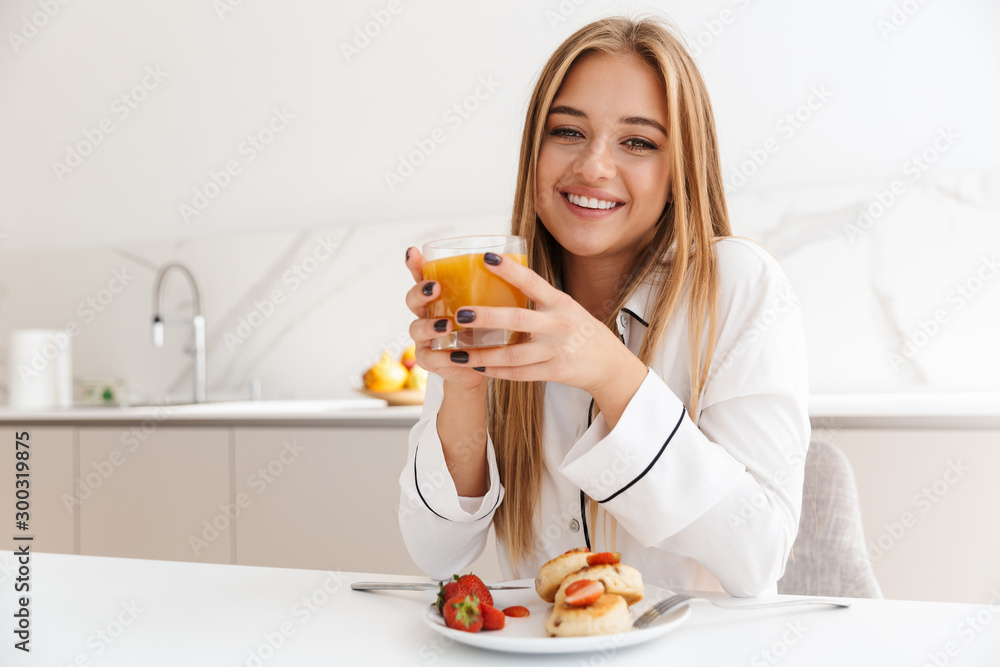 Photo of nice blonde woman having breakfast and smiling Photo of nice blonde woman having breakfast and smiling
