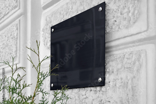 Foto Blank black glass signboard on gray textured wall mockup