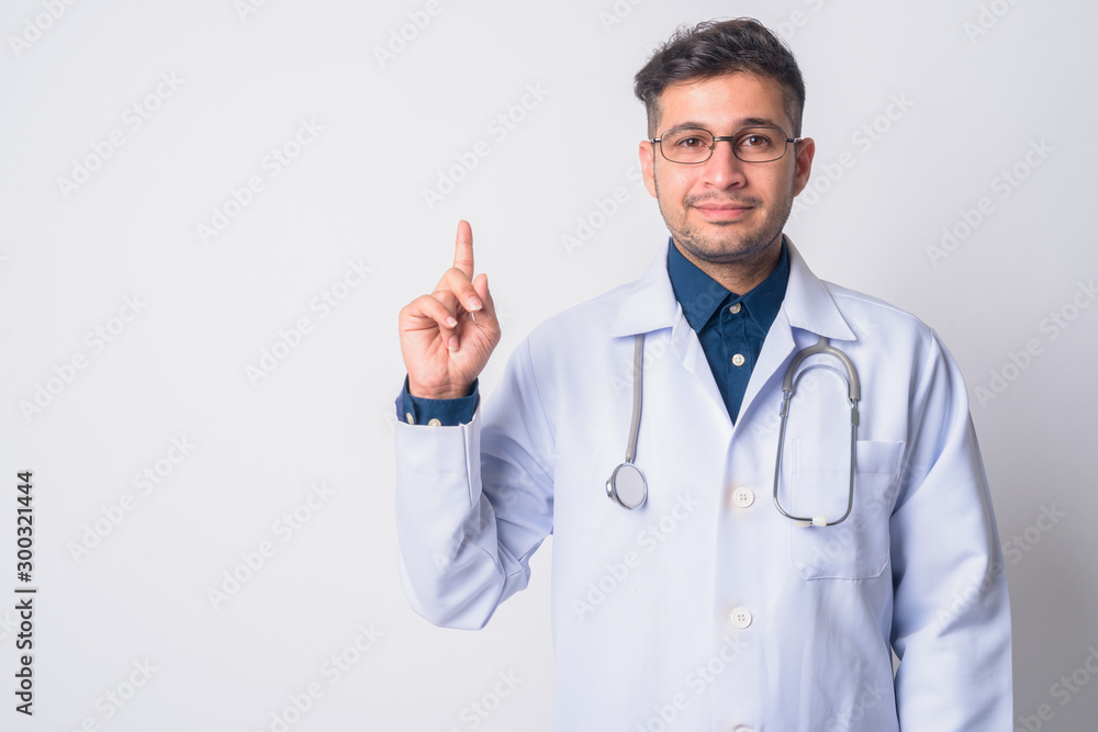 Portrait of young Persian man doctor pointing up Portrait of young Persian man doctor pointing up