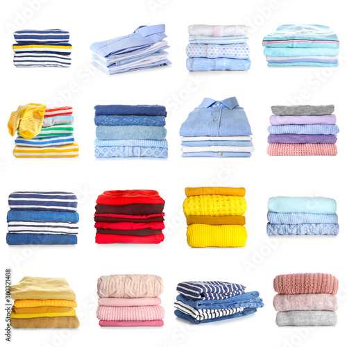 Stacks of modern different clothes on white background