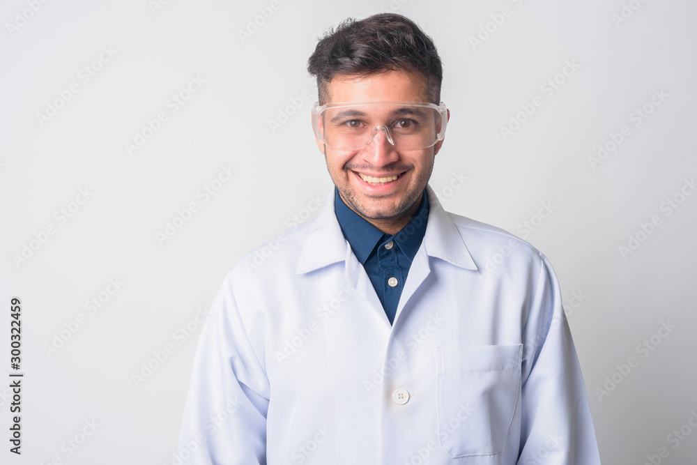 Face of happy Persian man doctor as scientist smiling Face of happy Persian man doctor as scientist smiling