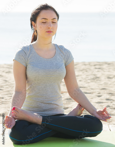 Girl doing cross-legged yoga pose © JackF