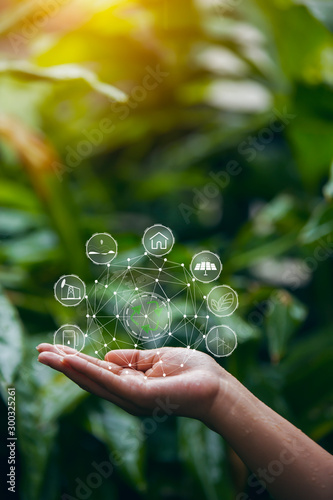 Technology, hand holding with environment Icons over the Network connection on green background 