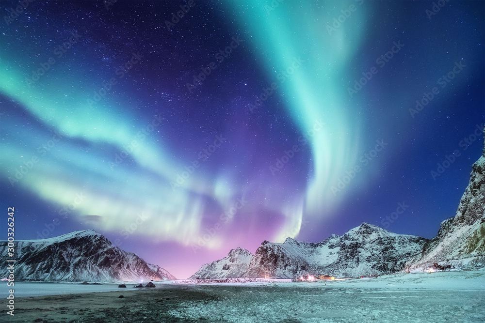Aurora borealis on the Lofoten islands, Norway. Green northern lights above mountains. Night winter landscape with aurora. Natural background in the Norway