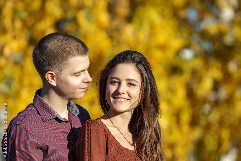Beautiful young couple in orange autumn leave. Handsome man and attractive woman, love story in autumn park. People relationships. Beautiful young couple in orange autumn leave. Handsome man and attractive woman, love story in autumn park. People relationships.