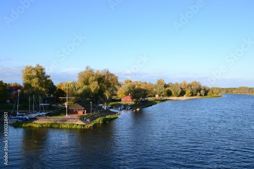 Small harbor or marina in Pultusk and beautiful Narew River, near the Bishops Castle. Pultusk, Poland. Autumn season photo