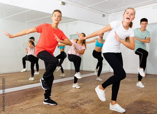 Teenage dancers practicing active vigorous dance in modern studio