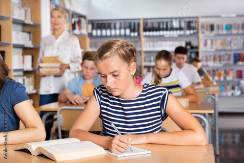 Fotografi Schoolgirl writing lesson in classroom