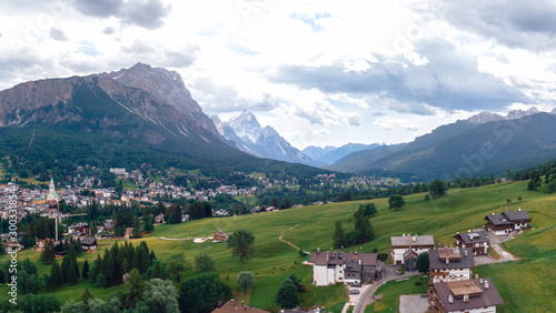 Tourist town Cortina d Ampezzo  panoramic view with alpine green landscape and massive Dolomites Alps. View of houses and hotels  the city from a height. Province of Belluno  South Tyrol  Italy.