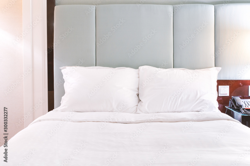 Clean and cozy modern hotel bedroom interior, warm tone room with a standing lamp, linen sofa with a cushion, design concept of luxury travel, close up. Clean and cozy modern hotel bedroom interior, warm tone room with a standing lamp, linen sofa with a cushion, design concept of luxury travel, close up.