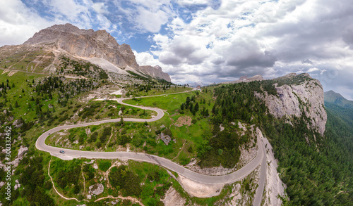 Fototapeta Naklejka Na Ścianę i Meble -  Aerial view of winding road surrounded by mountains, beautiful roads for traveling by motorcycle or car, the way of hikers and and cyclists, Falzarego Pass, Dolomites, Italy. Cortina d’Ampezzo.