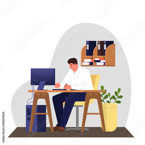 Man in a suit sitting at the desk and working on the computer