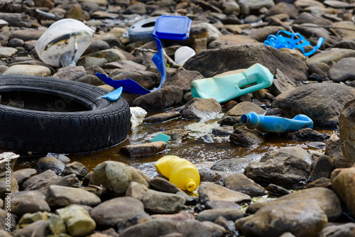 Plastic waste styrofoam and car tire on ocean shore. Environmental pollution global ecological problem.