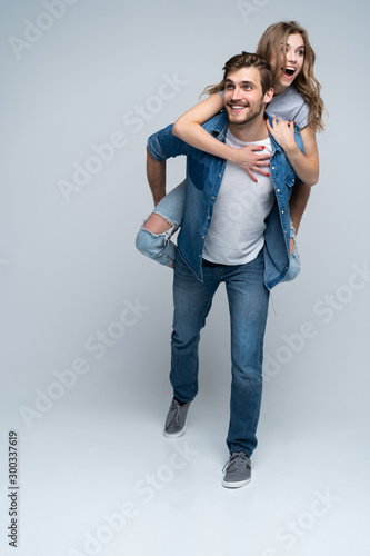 Cute portrait of couple. Guy rolls a girl on his back.