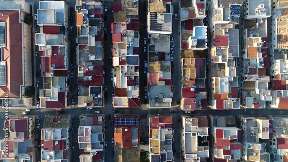 Aerial top down view of city building block located in metropolitan town flight over roofs and streets with vehicles driving around filmed by drone moving up slowly showing more of urban environment Aerial top down view of city building block located in metropolitan town flight over roofs and streets with vehicles driving around filmed by drone moving up slowly showing more of urban environment