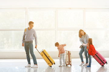 Happy family with luggage in airport