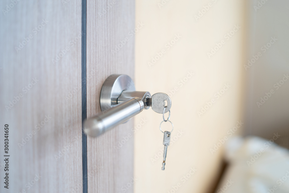 Opened door of hotel room with key in the lock