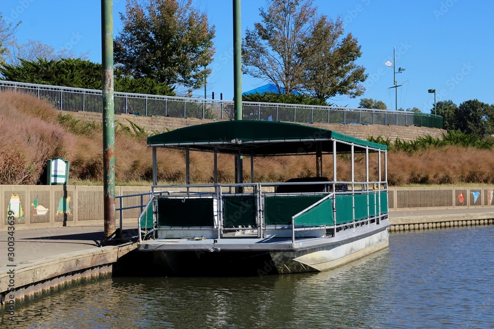 The sightseeing boat docked to the path at the park. The sightseeing boat docked to the path at the park.