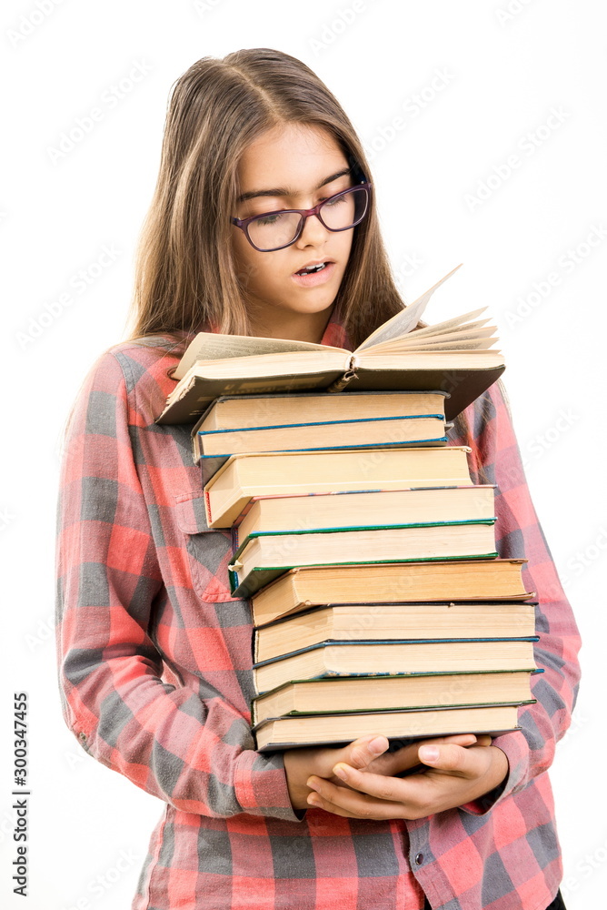 Girl with many books. student holds a large stack of books. Education. Printed books, study at school. Library. Beginning of studies at the Institute. Young girl with book in glasses Girl with many books. student holds a large stack of books. Education. Printed books, study at school. Library. Beginning of studies at the Institute. Young girl with book in glasses