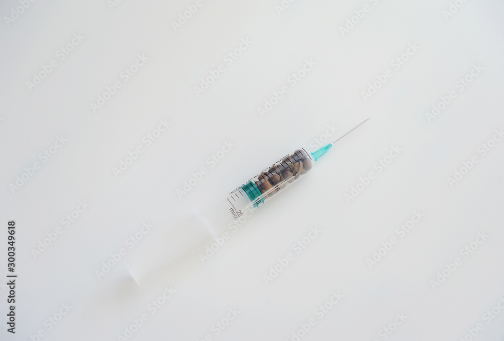 Coffee beans in a medical syringe. Caffeine addiction symbol Coffee beans in a medical syringe. Caffeine addiction symbol