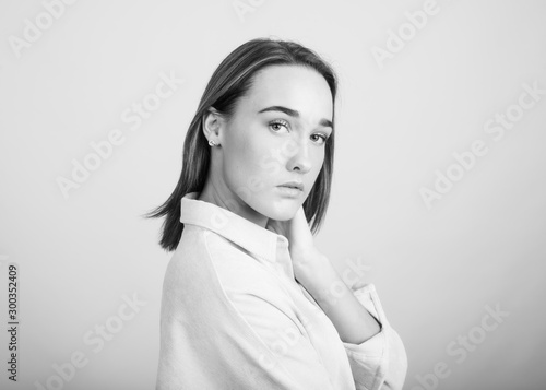 Black and white portrait of a brunette woman in front of light background