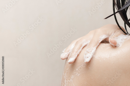 Woman taking a shower in the bathroom Rub the soap bubbles on the shoulders. copy space.