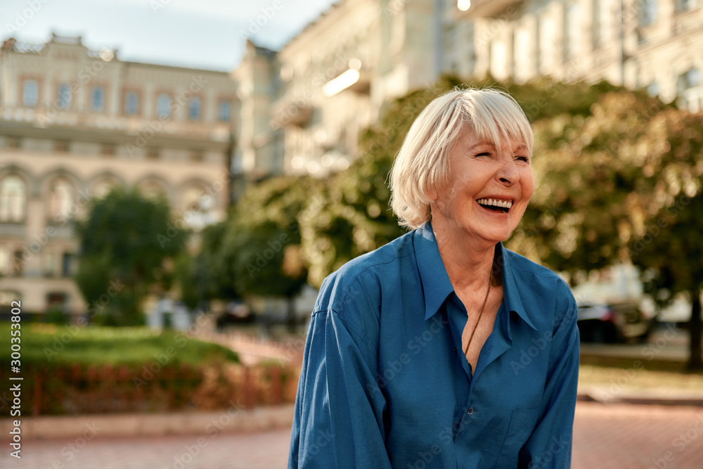 Don't stop laughing! Beautiful senior woman in casual wear smiling and feeling happy while standing outdoors on a sunny day Don't stop laughing! Beautiful senior woman in casual wear smiling and feeling happy while standing outdoors on a sunny day