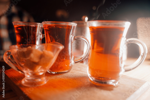 3 cups of black hot tea on table on dark background