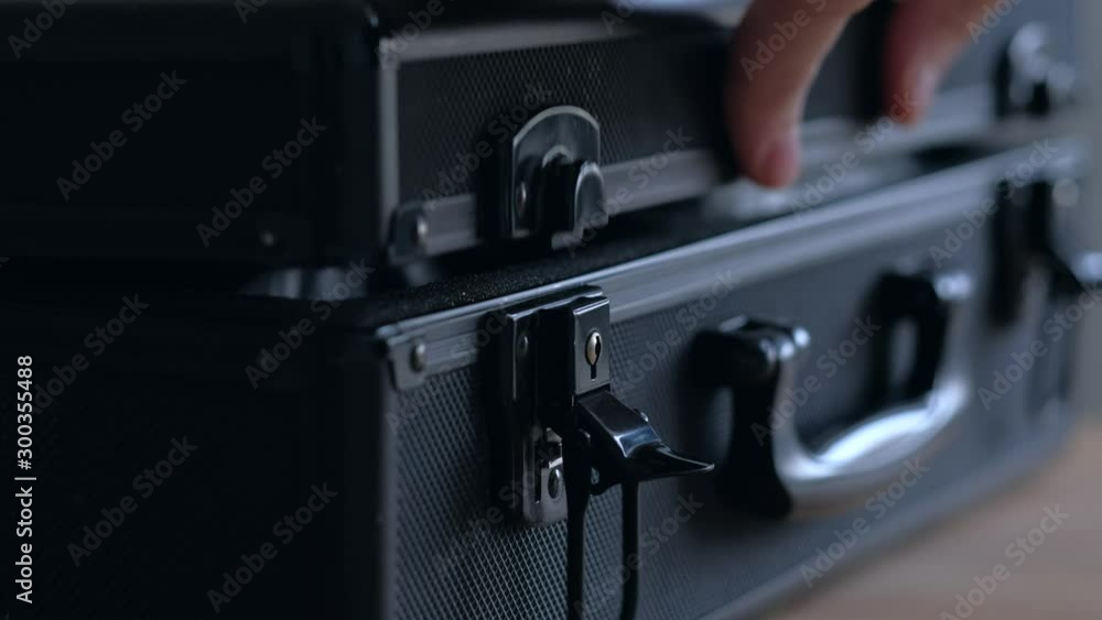 Concept of transportation of drugs. Hands of man open black case with drugs then close lock. Close up. Concept of transportation of drugs. Hands of man open black case with drugs then close lock. Close up.
