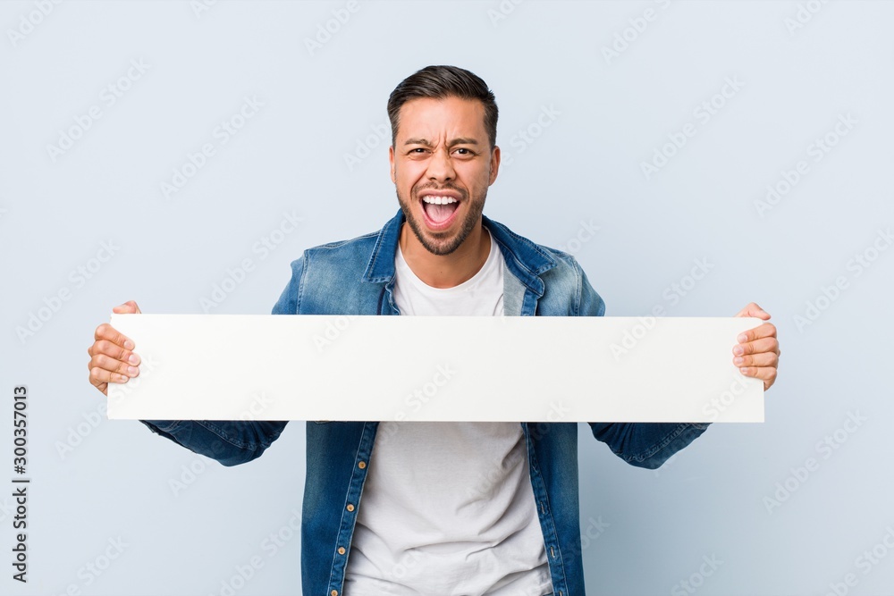 Young south-asian man holding a white placard. - obrazy, fototapety, plakaty 