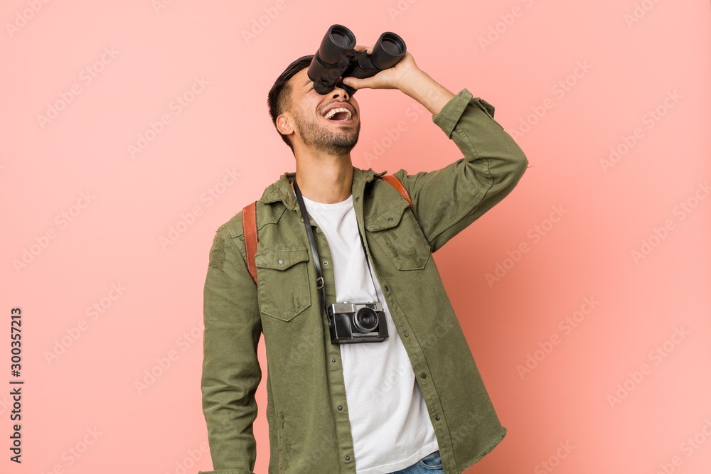 Young south-asian man looking through a binoculars. Young south-asian man looking through a binoculars.