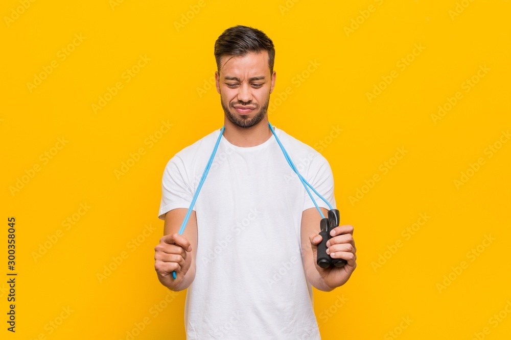Young south-asian man holding a jump rope. Young south-asian man holding a jump rope.