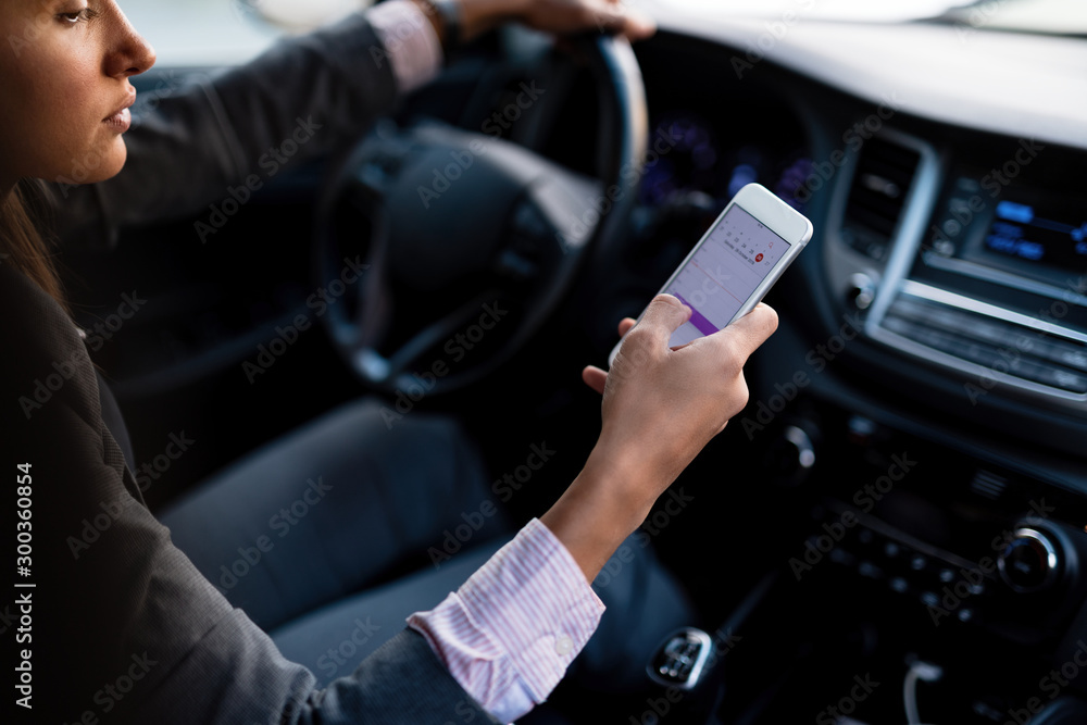 Close-up of woman using GPS on smart phone while driving a car. Close-up of woman using GPS on smart phone while driving a car.