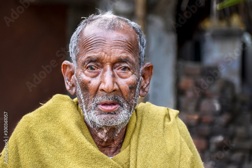 Foto A poor indigenous old man of India looks at the camera with astonished eyes