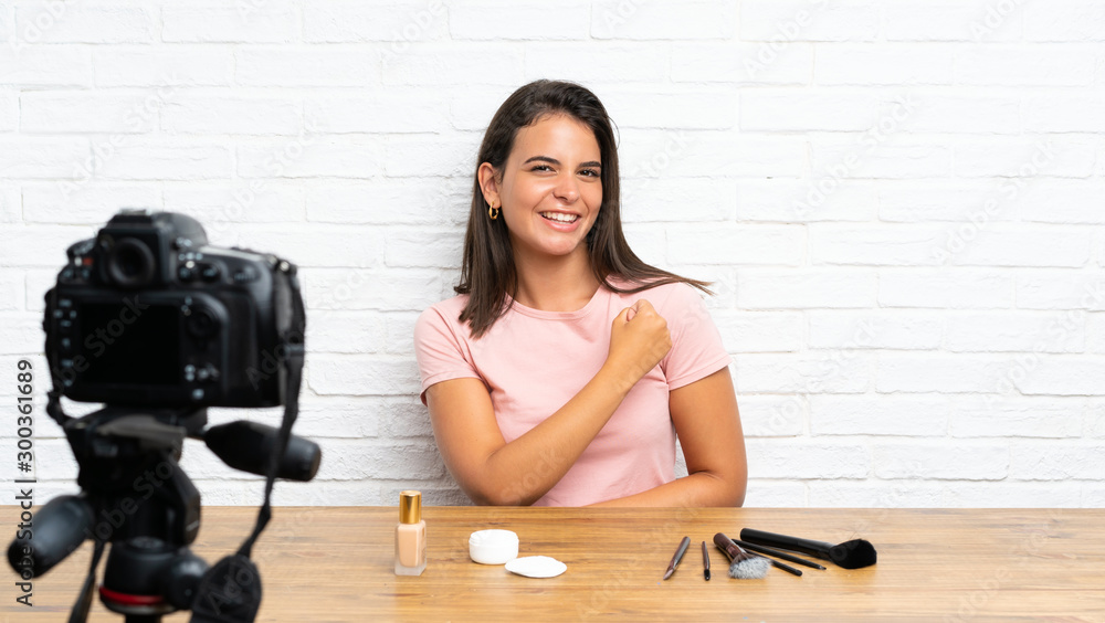 Young girl recording a video tutorial celebrating a victory