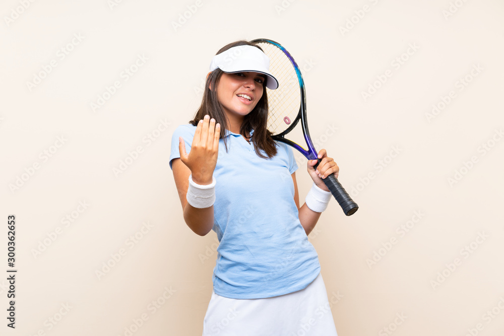 Young woman playing tennis over isolated background inviting to come with hand. Happy that you came Young woman playing tennis over isolated background inviting to come with hand. Happy that you came