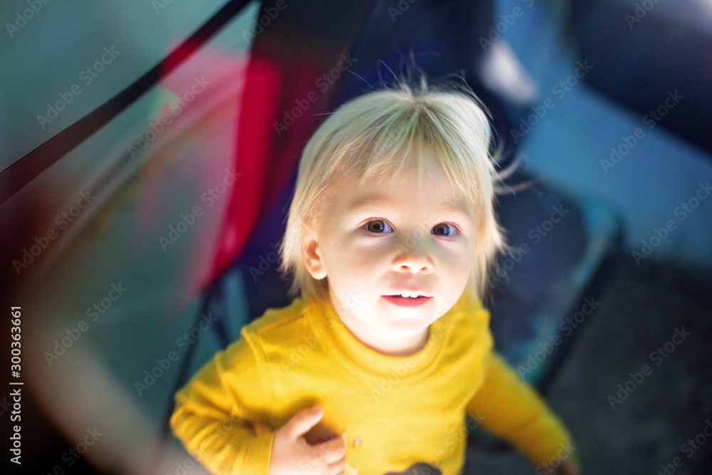Little toddler boy in a space ship, illuminated control panel, child as playing astronaut Little toddler boy in a space ship, illuminated control panel, child as playing astronaut