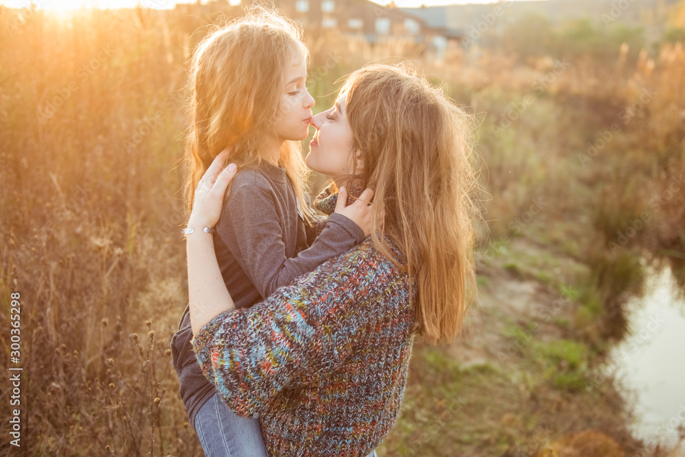 Portrait happy mother kissing child in warm sunny autumn day Portrait happy mother kissing child in warm sunny autumn day