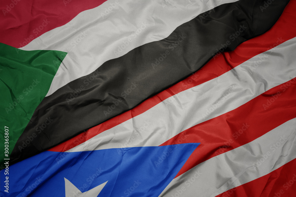 waving colorful flag of puerto rico and national flag of sudan. waving colorful flag of puerto rico and national flag of sudan.